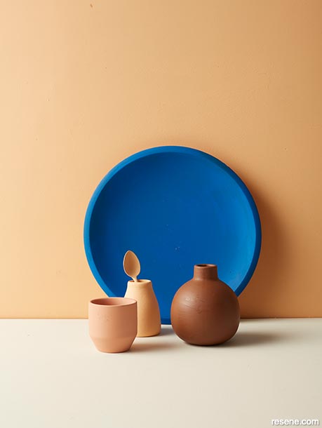 A painted blue plate against brown backdrop