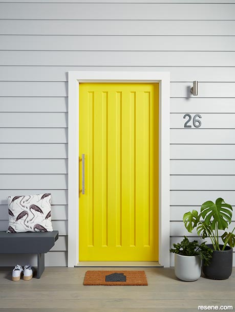 A vibrant yellow front door in Resene Turbo