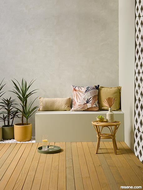 An outdoor patio with a textured wall