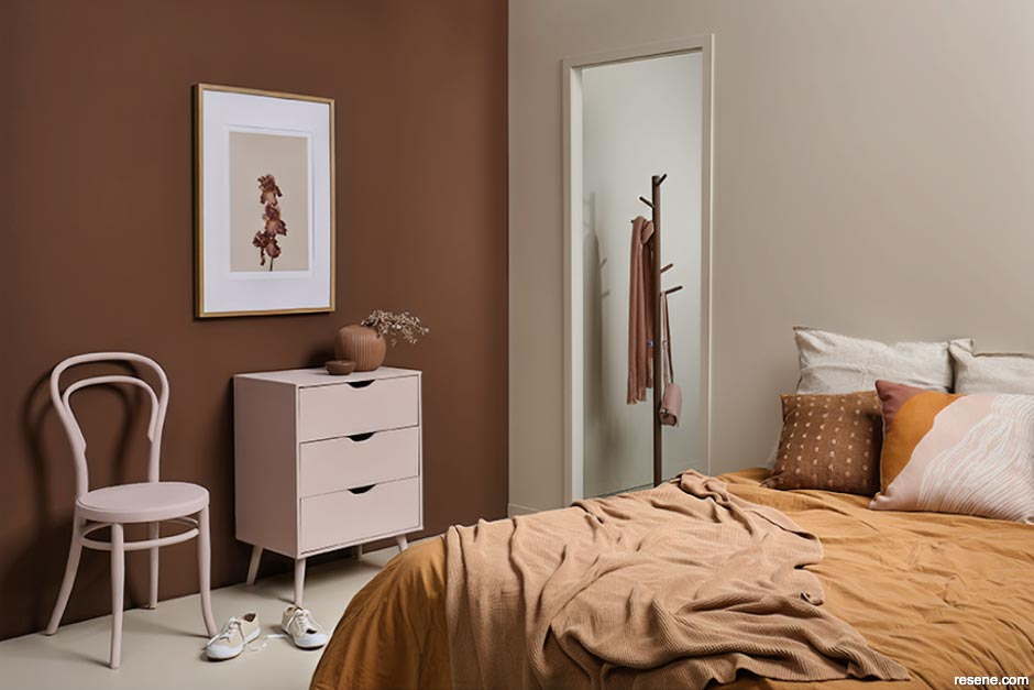 A bedroom with warm Earthy pink and spicy mustard hues