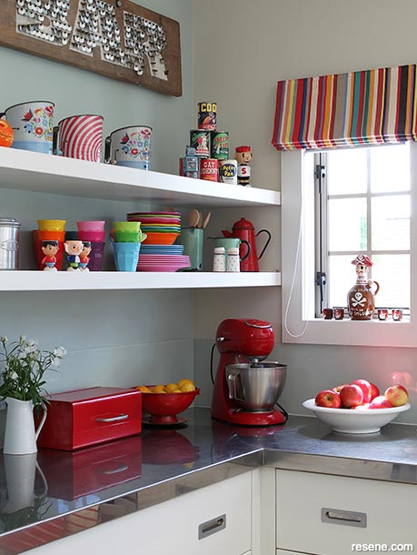 A light blue kitchen with colourful accessories