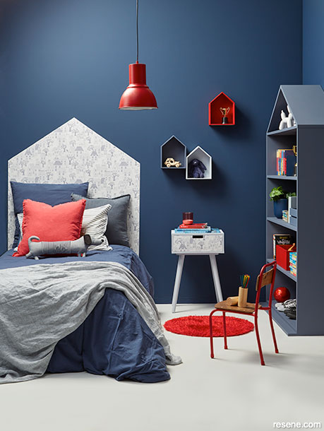 A dark blue kids room with red accessories