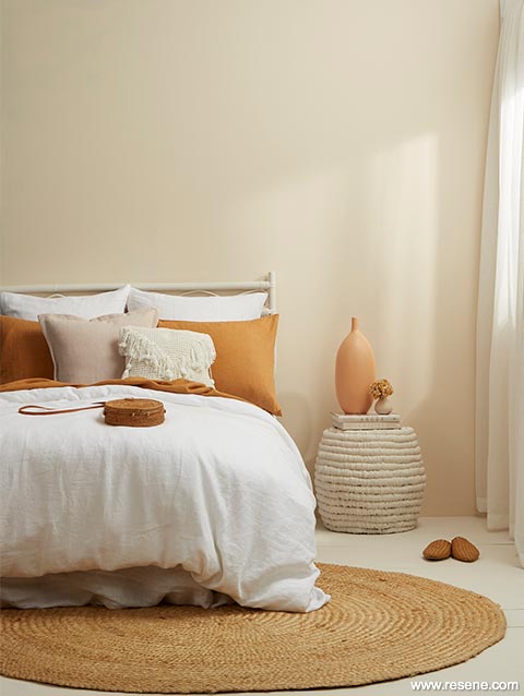 Neutral boho bedroom with terracotta cushions