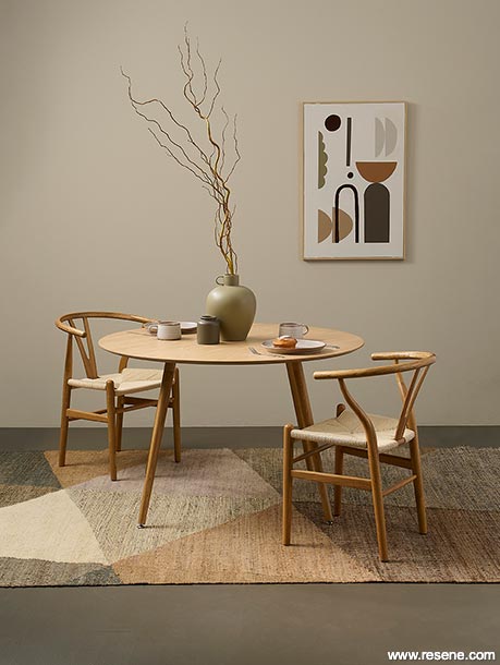 A brown and neutral dining room with a rug