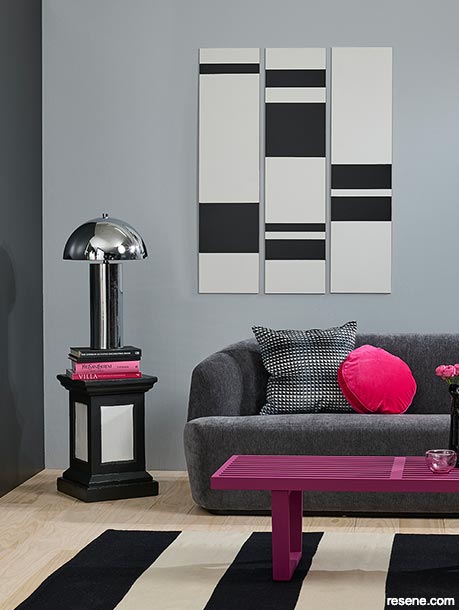 A grey lounge with pink and magenta accessories